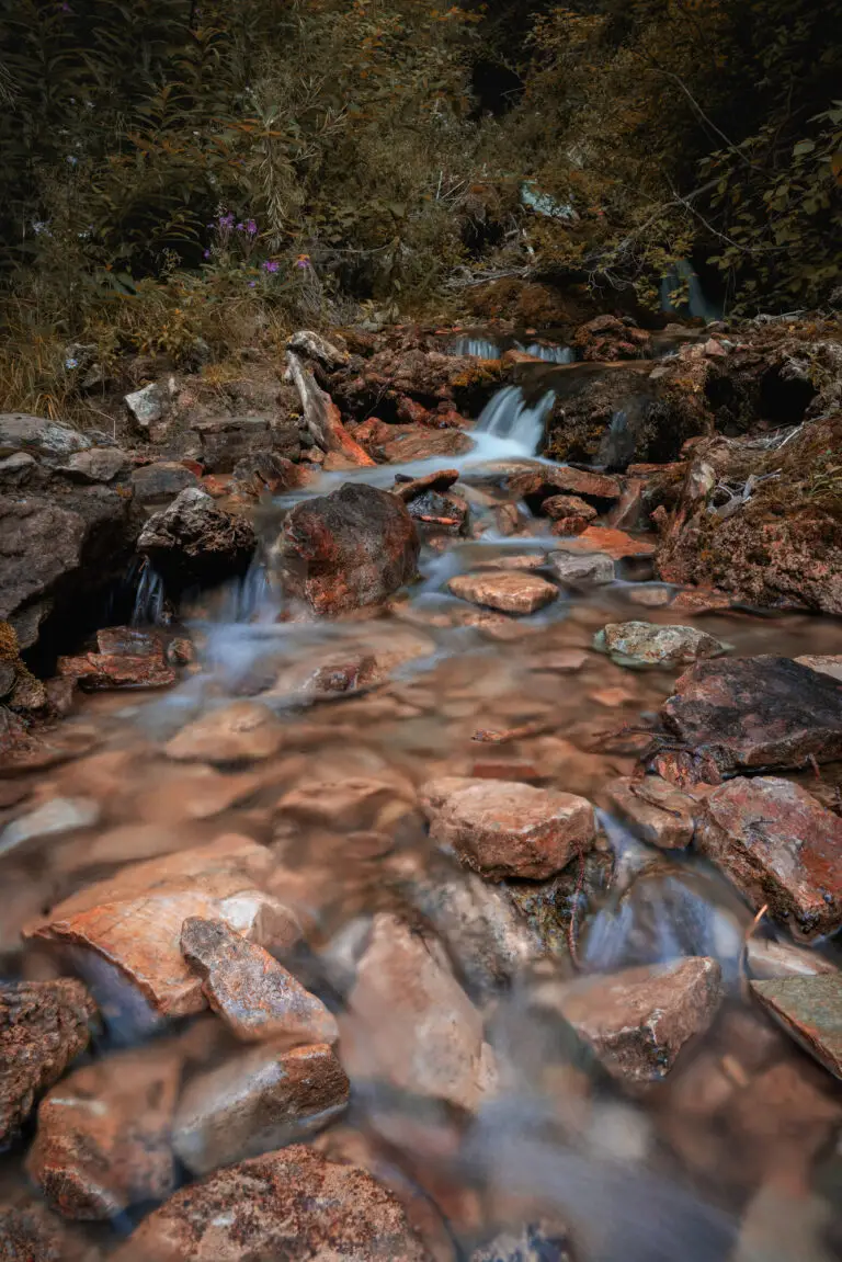 Colorado Photography Locations Colorado Photography Locations Rugged rocky stream in a dense forest with water flowing over orange brown rocks in a soft silky state from long exposure