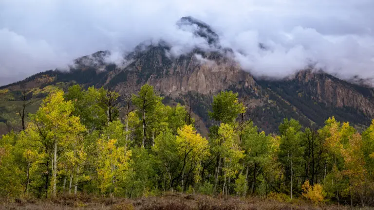 Colorado Photography Locations Colorado Photography Locations Mountain peak partially hidden by low clouds with a colorful aspen forest in the foreground